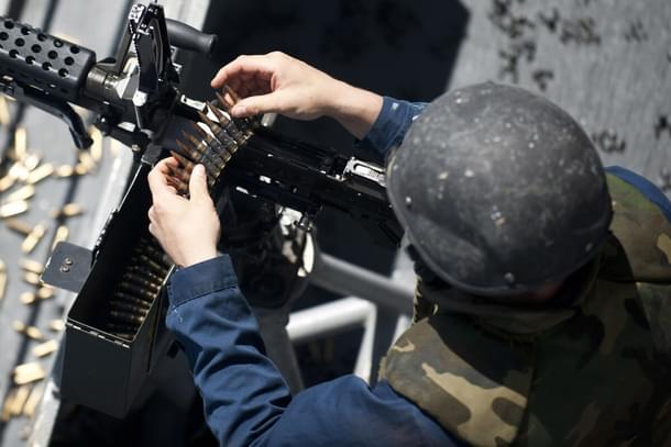 Fire Controlman Miguel Marsiglia reloads an M240G light machine gun.