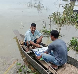 PayNearby staffer offering services on a boat in Assam during recent floods