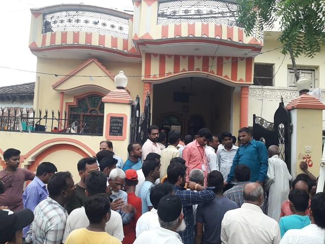 Locals outside the victims’ house on 28 June