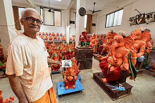 Prabhakar Rao with a picture of his father Mohan Rao at work and the dozens of Ganeshas at the workspace.