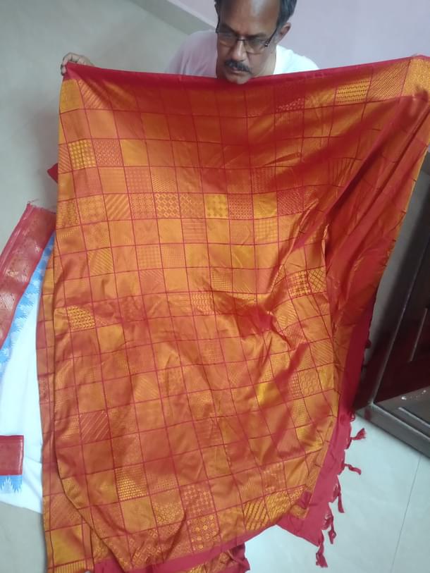 Master weaver B Krishnamoorthy holds his sari of 5015 Kanjeevaram design document shown in small boxes. (Madhurya Creations)