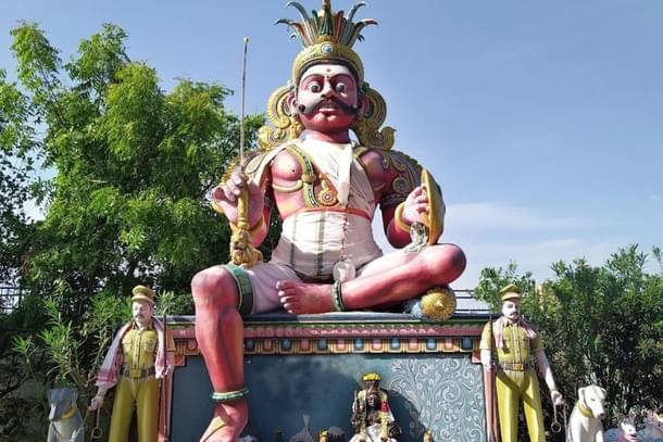 The village guardian Deity in a temple in Tamil Nadu, flanked by policemen and two police dogs.