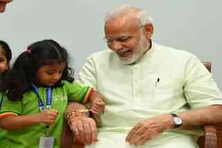 A girl ties 'Rakhi' on PM Modi's wrist on the occasion of Raksha Bandhan (Source: PIB) 