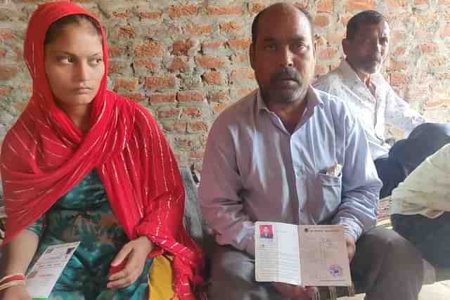 Asha Ram shows a picture of Sunil. On his right is his daughter Roshni.