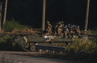 Ukrainian soldiers riding on an armoured vehicle in Kharkiv on Friday. 