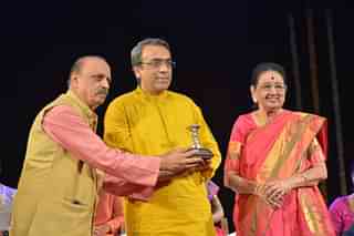 Veena D Balakrishna receiving the prestigious Ananya Puraskar from vocalist Neela Ramagopal and Dr MRV Prasad.