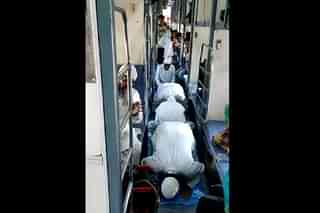 A screengrab of the viral video showing muslim men offering namaz on train corridor (via Twitter)