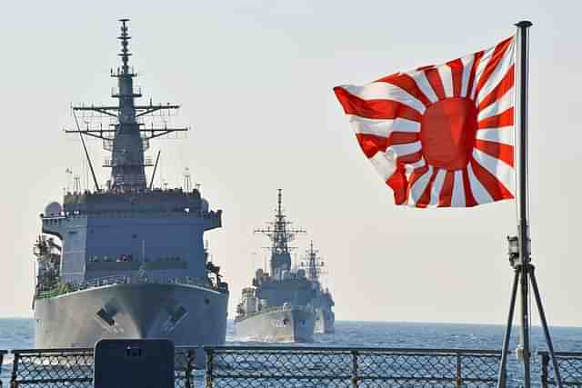 The rising sun flag with Japanese naval vessels in the background.