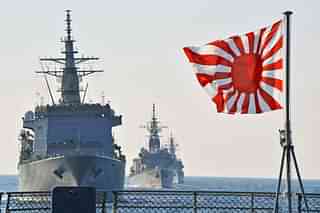 The rising sun flag with Japanese naval vessels in the background.