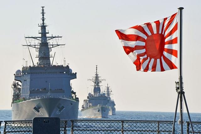 The rising sun flag with Japanese naval vessels in the background.