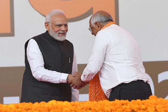 New Gujarat Chief Minister Bhupendra Patel shakes hands with Prime Minister Narendra Modi after taking oath.  