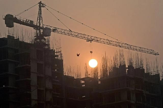 Sun rises over an under-construction apartment building on the outskirts of New Delhi. (PRAKASH SINGH/AFP/Getty Images)
