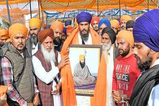 Amritpal Singh (centre) being presented with a portrait of slain militant Jarnail Singh Bhindranwale, after he took over as head of 'Waris Punjab De'. (Image: Twitter).