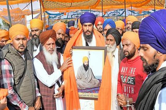 Amritpal Singh (centre) being presented with a portrait of slain militant Jarnail Singh Bhindranwale, after he took over as head of 'Waris Punjab De'. (Image: Twitter).