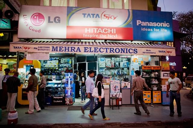 People make their way past an electronics retailer in Khan Market, New Delhi. (Daniel Berehulak/Getty Images)