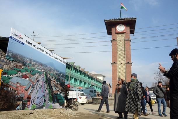 People look at the map of 'Redevelopment of Lal Chowk' put up by the Government under the Srinagar Smart City project at  Ghanta Ghar. (Twitter/Umar Ganie)
