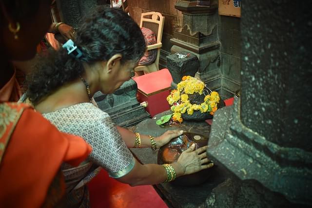 A woman devotee touching the Chintamani stone