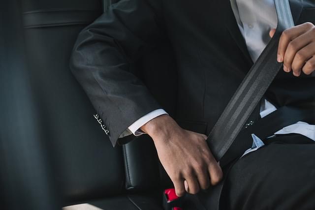A passenger fastens the seat belt in a car (Representative image).