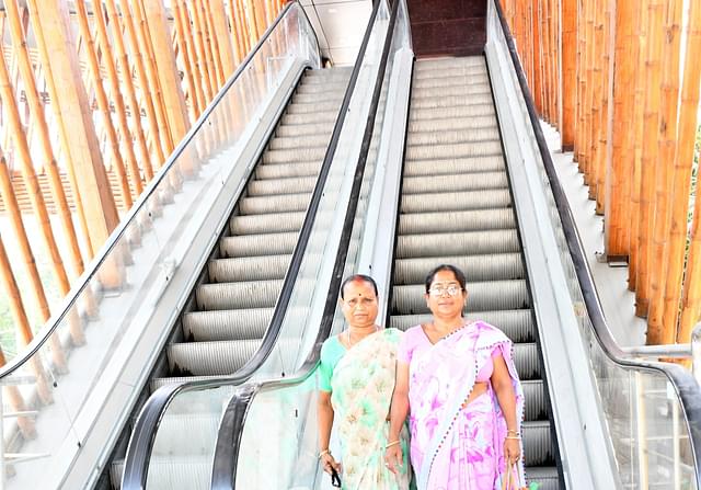 Junmoni Das (right, holding a bag) with her sister Maina on the Khanapara pedestrian footbridge. (Moon Mostaque)
