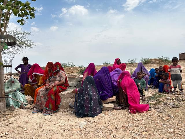 Women sitting near a demolished water tank
