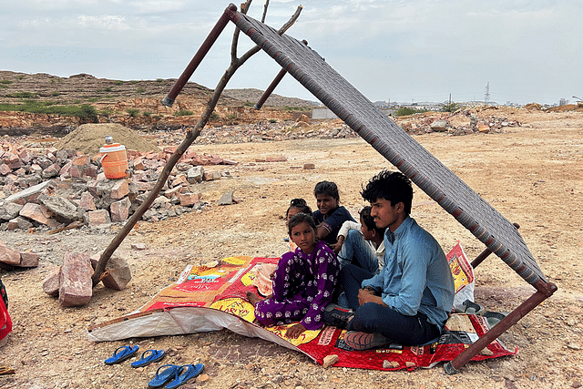 A family sitting under shade of a charpoy on 28 April.