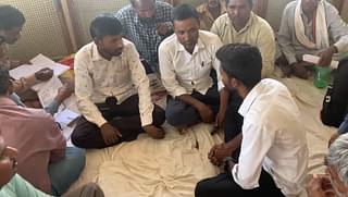 Men preparing list of affected families. Kishanraj is the one on the left in white shirt 