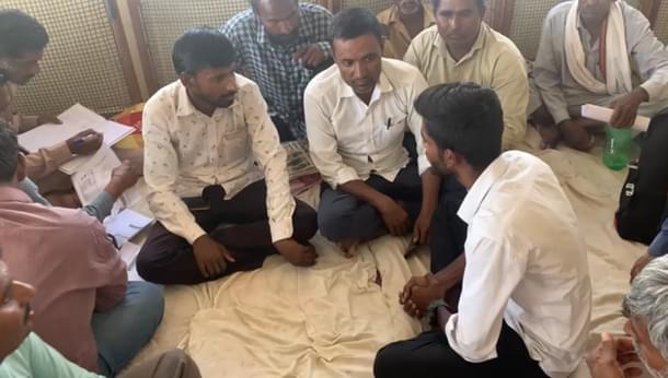 Men preparing list of affected families. Kishanraj is the one on the left in white shirt