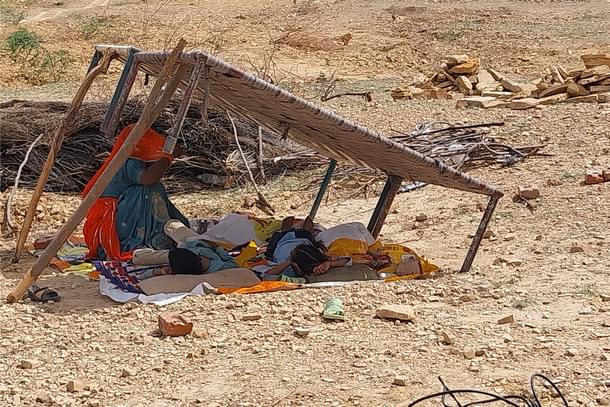 A family under the shade of a cot.