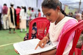 A woman volunteer looking at a register.