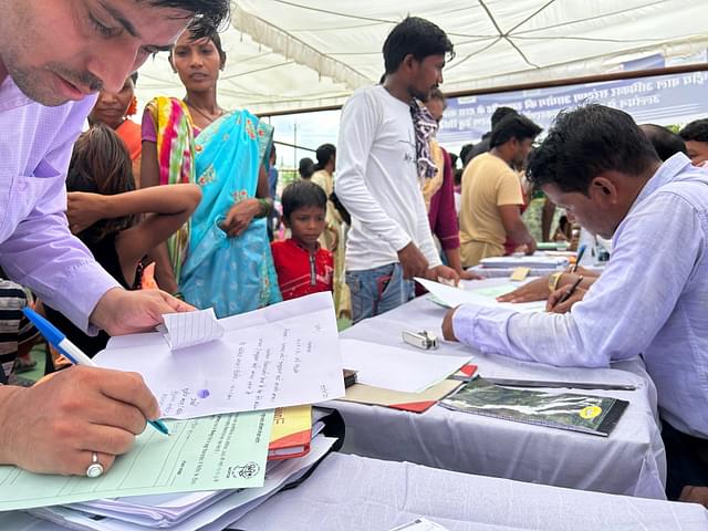 Officials filling forms for villagers.