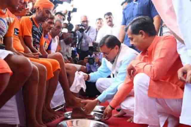 Uttarakhand Chief Minister Pushkar Singh Dhami at the Kanwar Mela, in Haridwar, Saturday, July 8, seen washing feet of Kanwar Yatris. (Pic: Twitter)