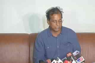 Rajendra Gudha reading from alleged red diary during press conference