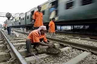 Indian Railways workers perform track maintenance at a station in Kolkata.