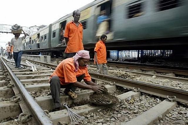 Indian Railways workers perform track maintenance at a station in Kolkata.