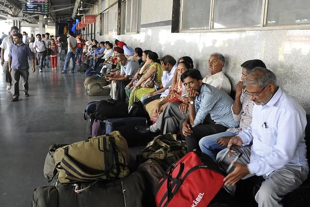Passengers sitting on the platform at New Delhi Railway Station.
