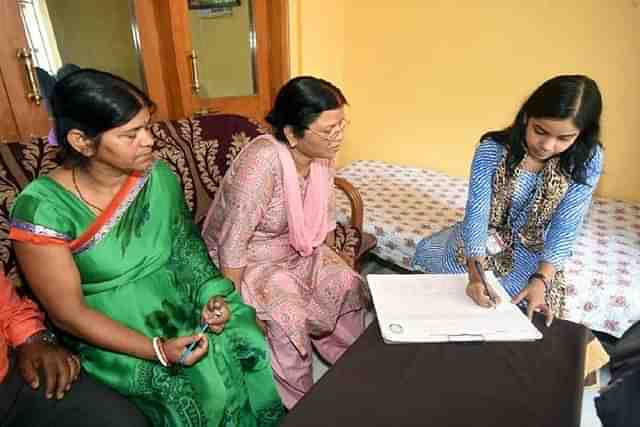 A schoolteacher (right) enumerating a household.