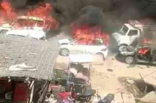 A picture of cars being burnt near the procession in Nuh.