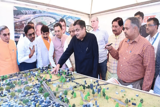 Union Minister Nitin Gadkari and other officials reviewing an expressway model.