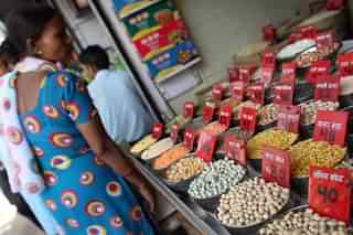 A woman checks the price of pulses and grains at a wholesale market in New Delhi. Photo Credit: MANAN VATSYAYANA/AFP/Getty Image
