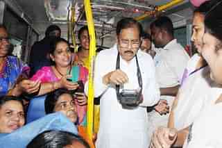 Karnataka's Home Minister G Parameshwara issues bus tickets to women passengers in a bus. 