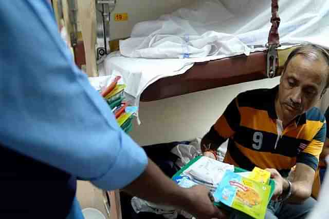 A passenger being handed over the IRCTC breakfast tray containing the Godrej Yummiez millet patty. (X)