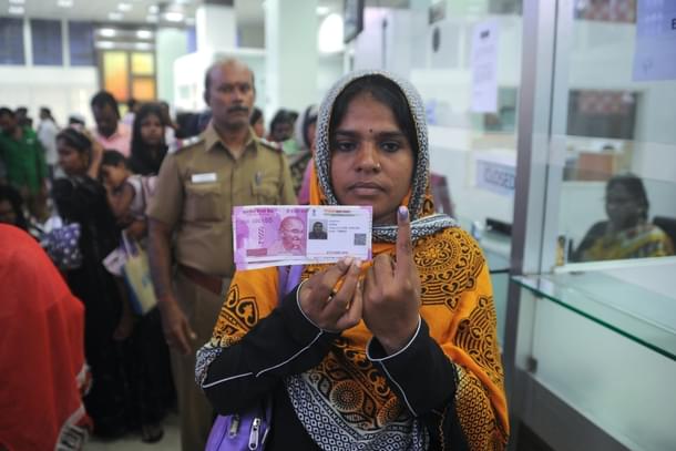 A Indian woman poses with new 2000 rupee notes. (ARUN SANKAR/AFP/Getty Images)