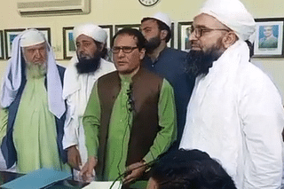 Professor Sher Ali (in green) forced to read an affidavit denouncing theory of evolution.