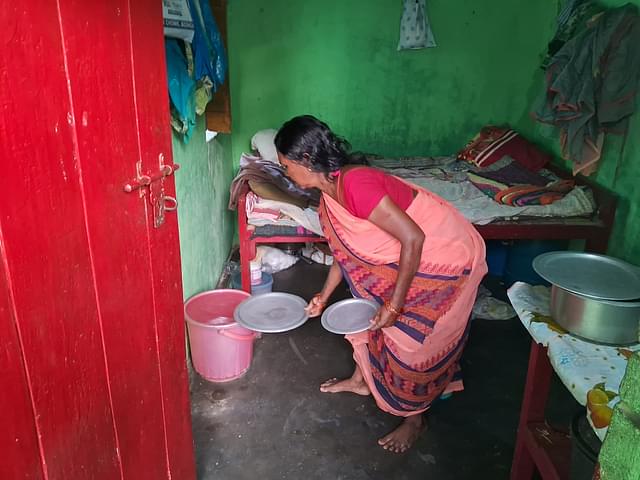 Muniya Devi showing the water buckets she stored for the day. (Source: Swarajya)