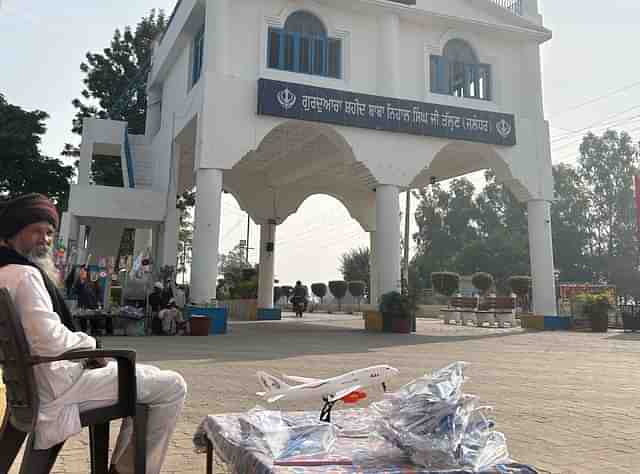 A shopkeeper sells toy airplanes outside the Talhan gurudwara. 