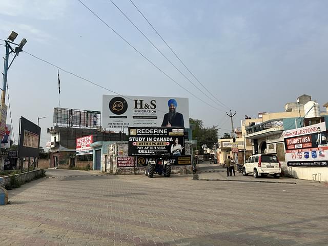 Advertisements for IELTS coaching and overseas visa assistance just outside the gurudwara