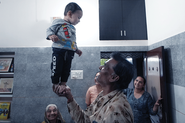 Ashok Prajapati's brother playing with his grand-nephew. (Sharan Setty/ Swarajya)