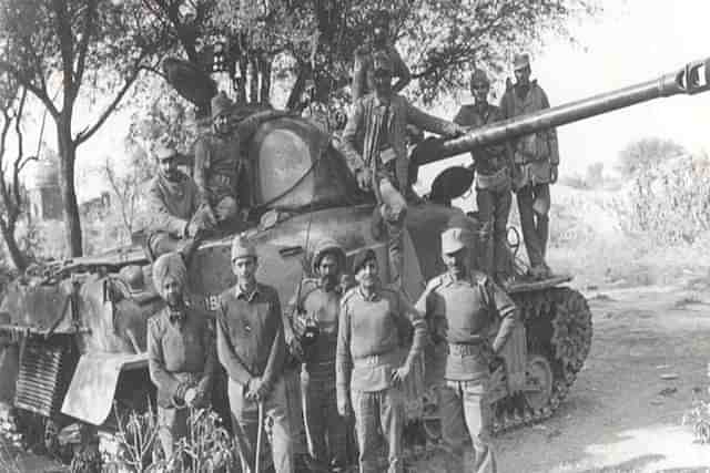 Indian Army soldier posing in front of a tank. 