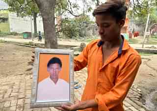 Rajendra Prasad Dharkar's nephew holds his uncle's picture