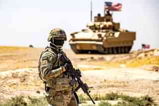 A US military soldier standing in front of a US Bradley infantry fighting vehcile. (Delil Souleiman/AFP via Getty Images)